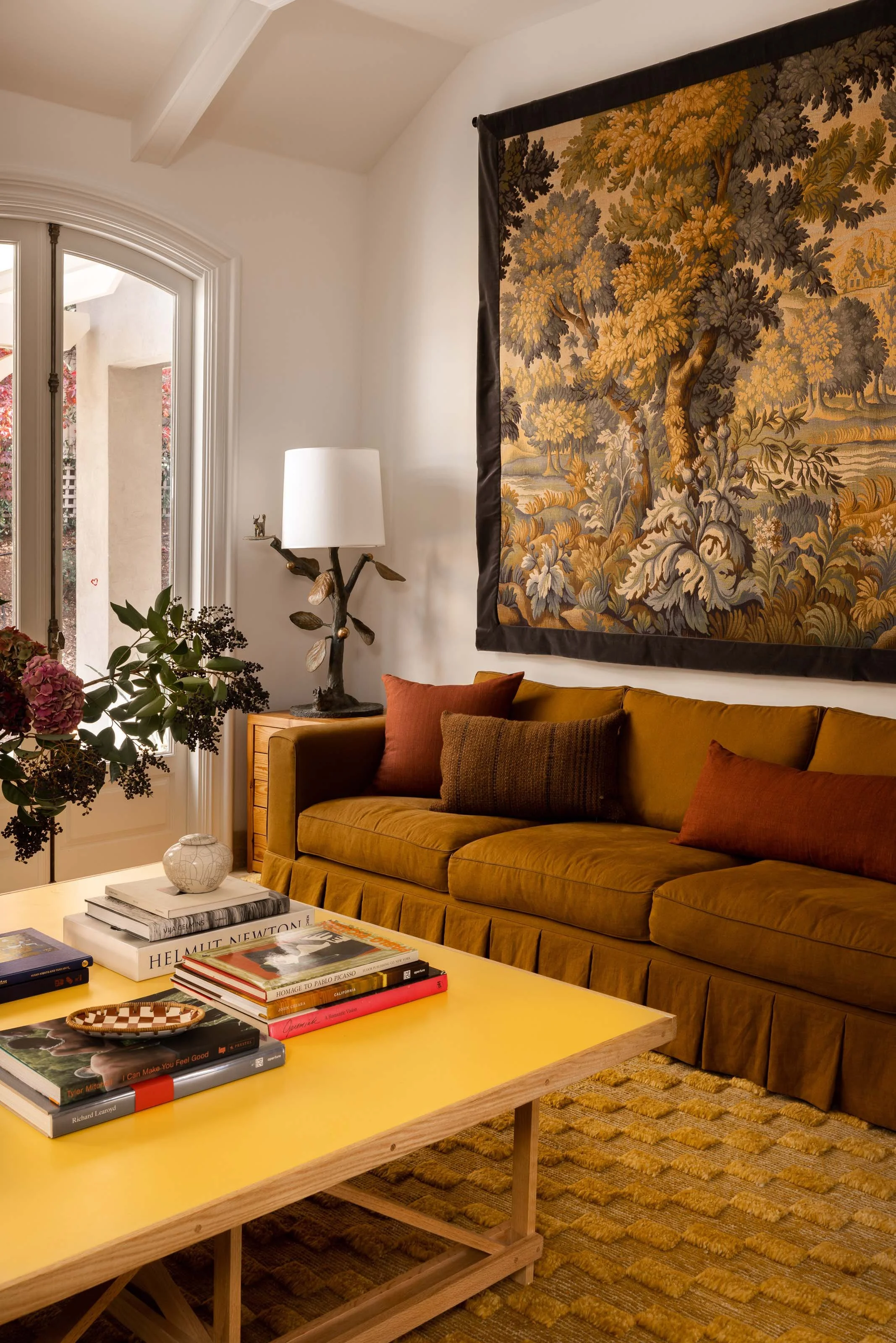 A family room with a deep sectional, layered textiles and a sculptural floor lamp, designed by Studio Montemayor.